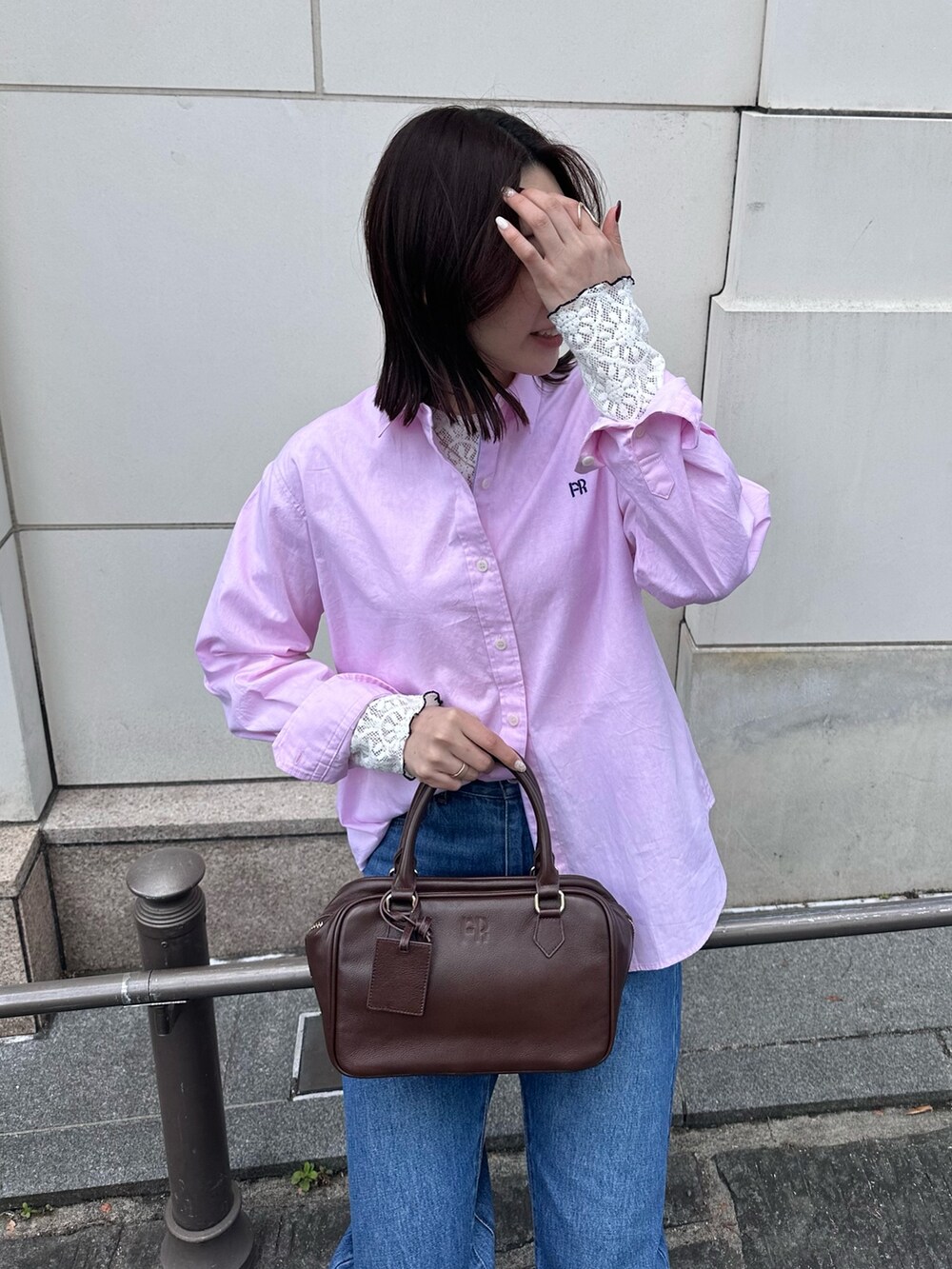 ブルー系のデニムパンツ、ブラウン系のハンドバッグ、ピンク系のシャツ/ブラウスを着用したレディースの冬コーディネートの8枚目の写真