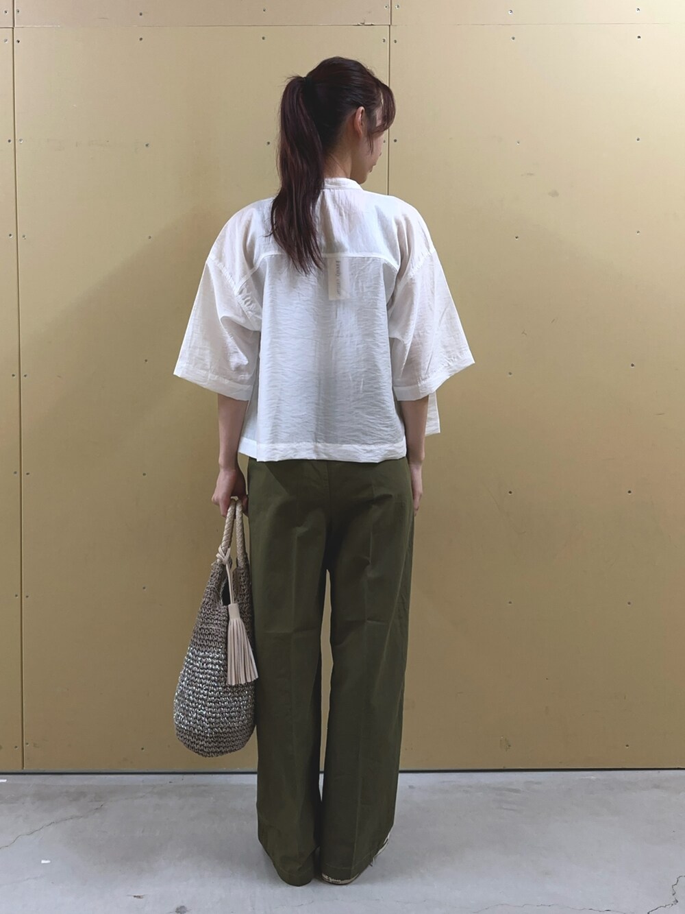 グリーン系のチノパンツ、ホワイト系のシャツ/ブラウス、ベージュ系のTシャツ/カットソーを着用したレディースの夏コーディネートの3枚目の写真