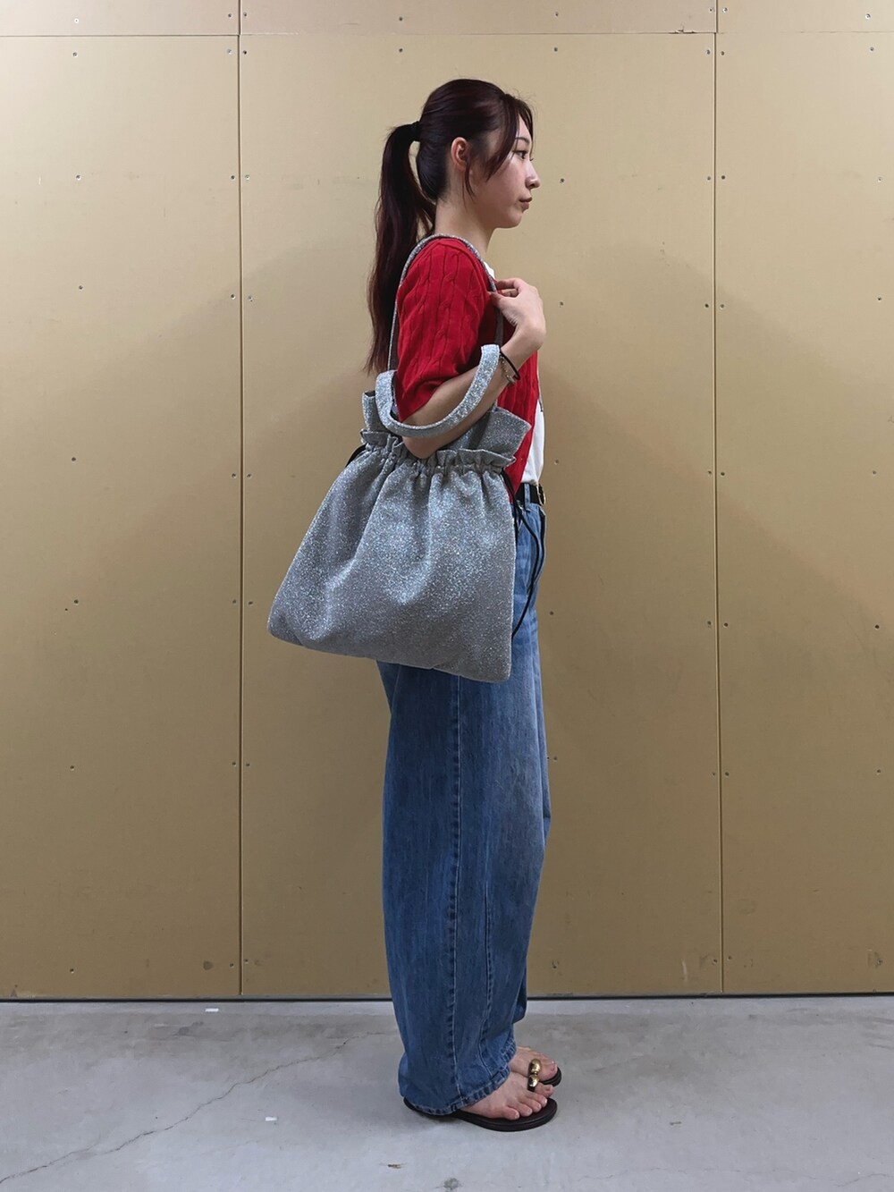 ブルー系のデニムパンツ、ホワイト系のTシャツ/カットソー、シルバー系のトートバッグを着用したレディースの夏コーディネートの4枚目の写真