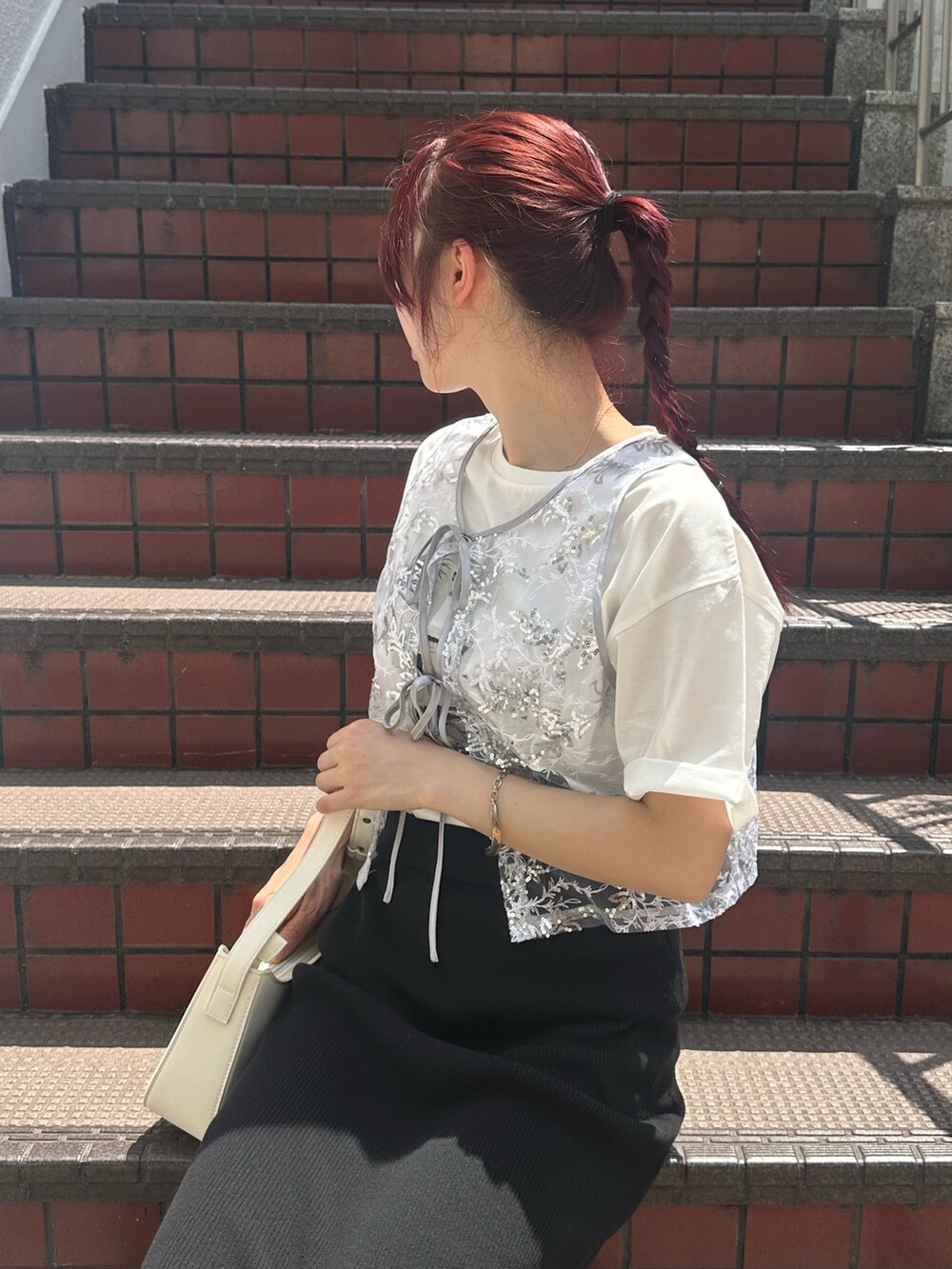 ブラック系のスカート、ブラック系のサンダル、シルバー系のベストを着用したレディースの夏コーディネートの3枚目の写真