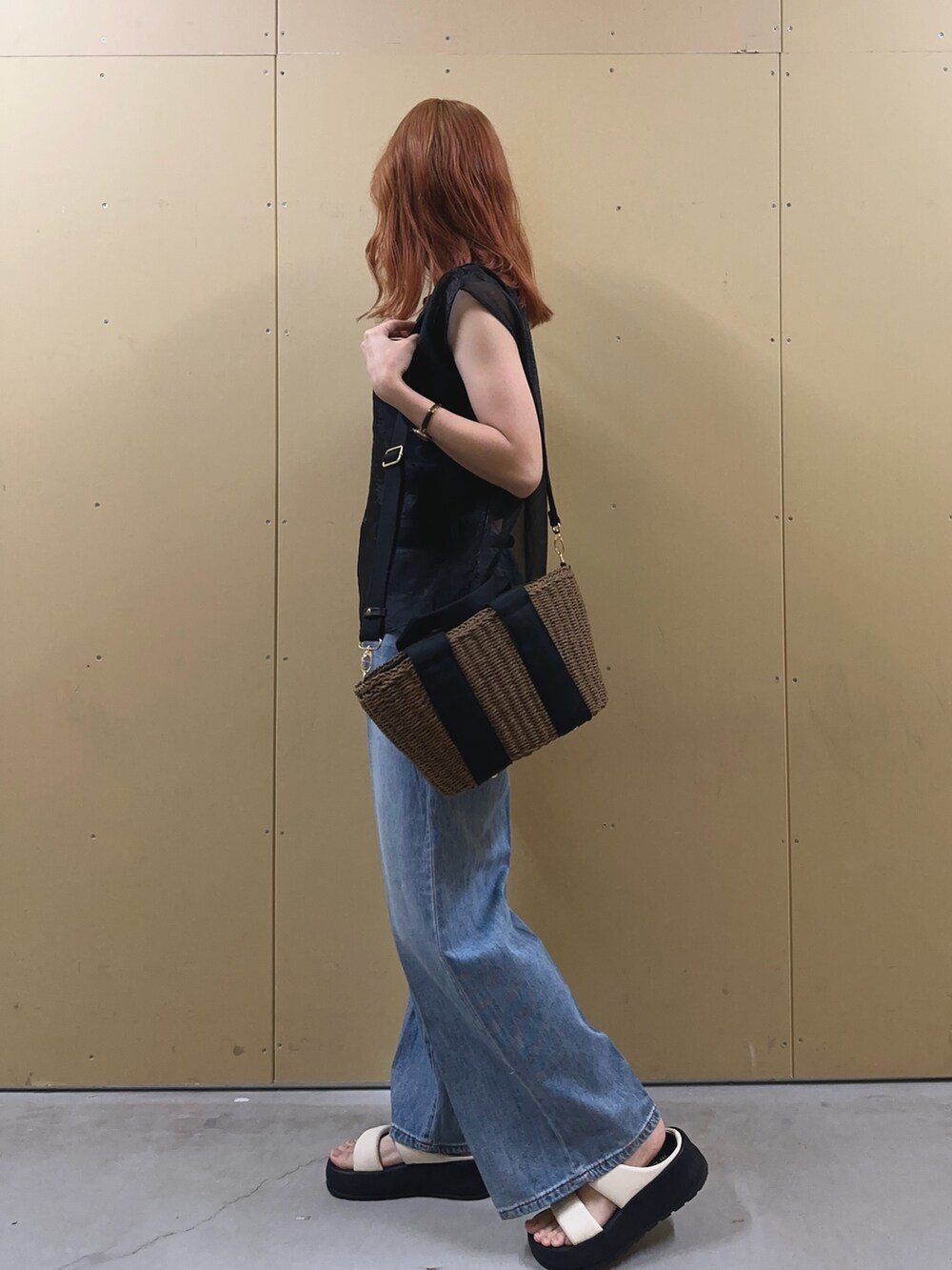 ブラック系のシャツ/ブラウス、ブルー系のデニムパンツ、ブラック系のかごバッグを着用したレディースの夏コーディネートの5枚目の写真
