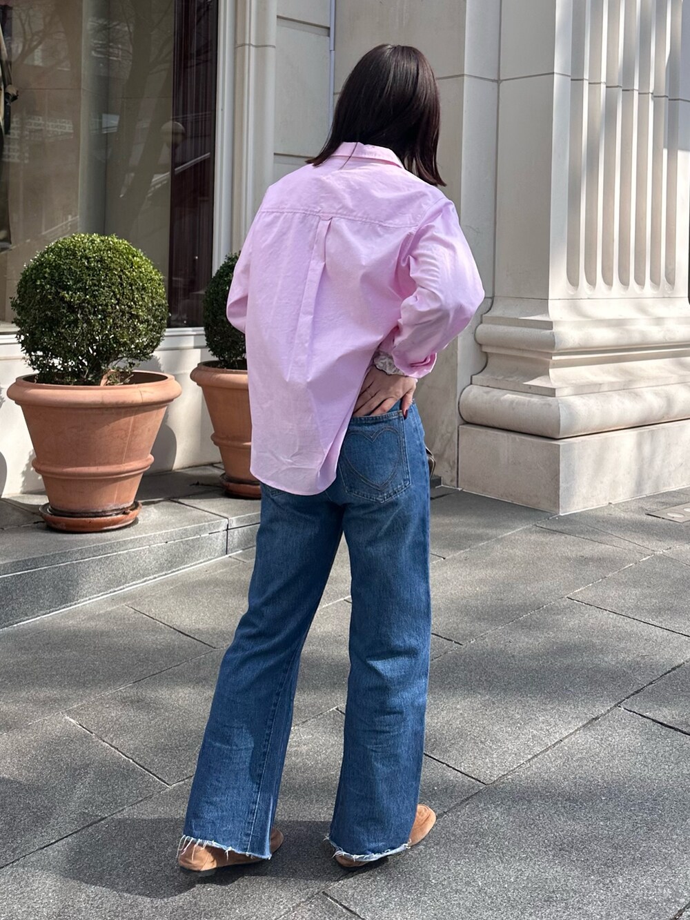 ブルー系のデニムパンツ、ブラウン系のハンドバッグ、ピンク系のシャツ/ブラウスを着用したレディースの冬コーディネートの4枚目の写真