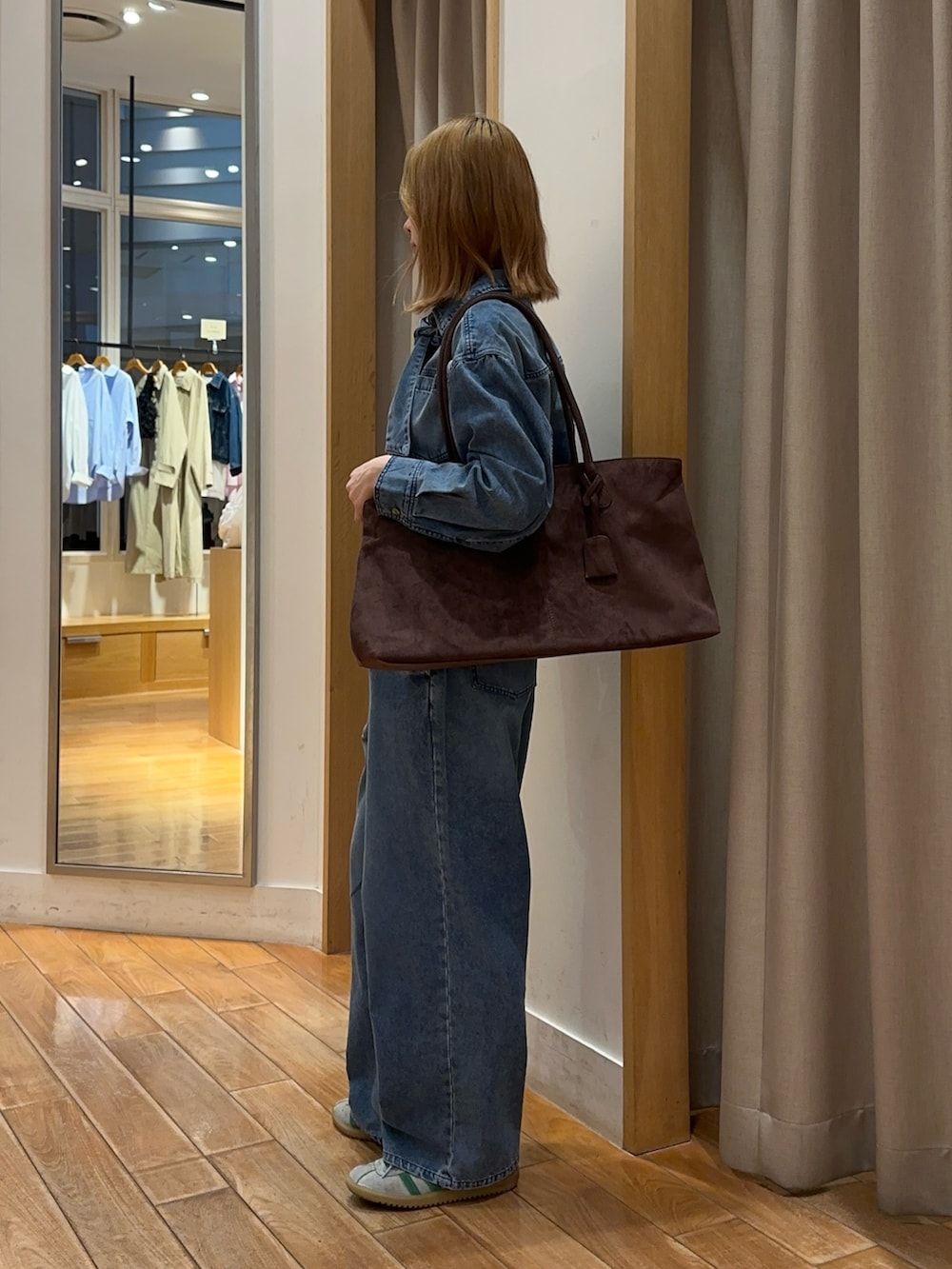 ブルー系のシャツ/ブラウス、ブルー系のデニムパンツ、ブラウン系のトートバッグを着用したレディースの春コーディネートの6枚目の写真