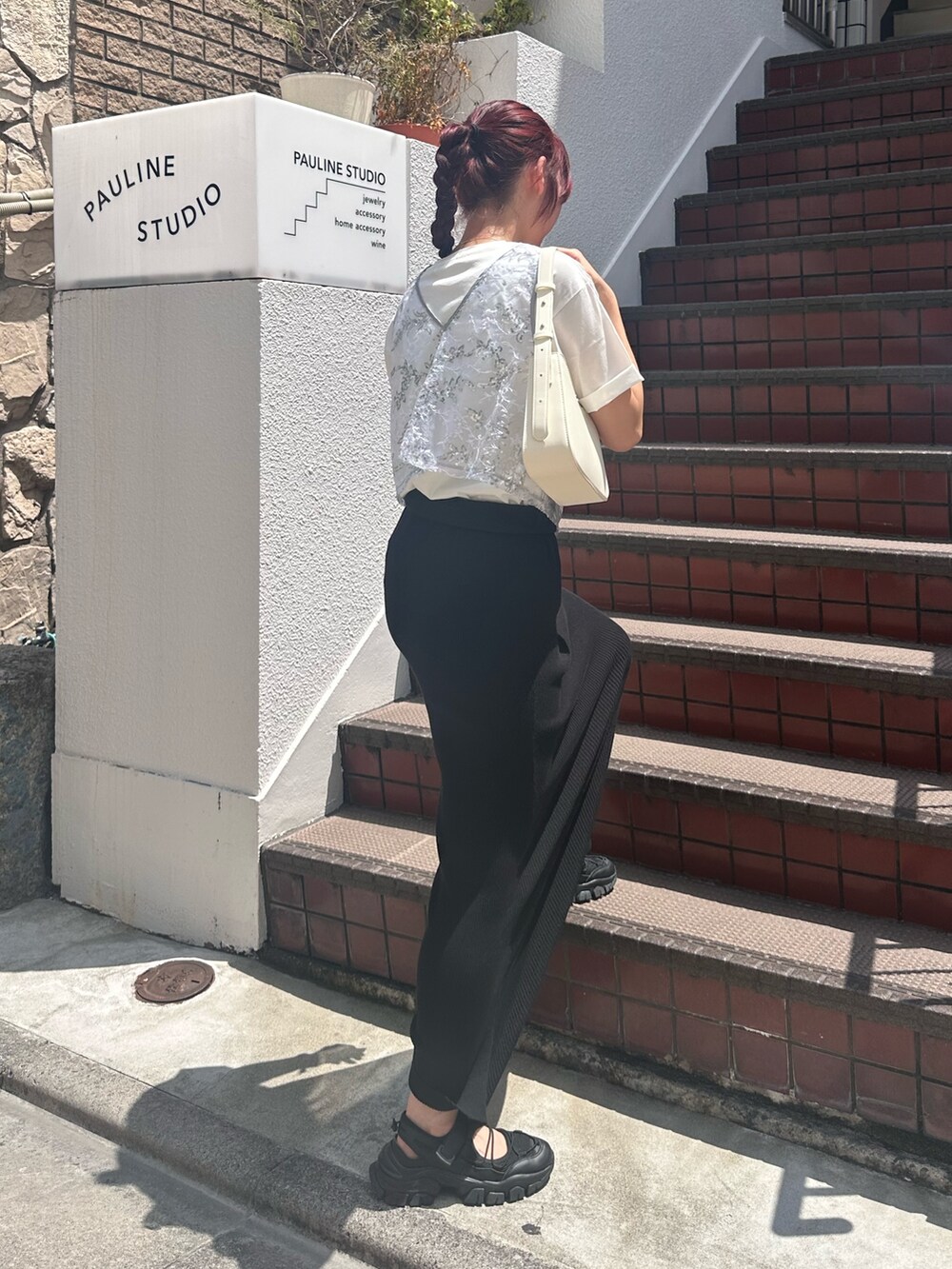 ブラック系のスカート、ブラック系のサンダル、シルバー系のベストを着用したレディースの夏コーディネートの7枚目の写真