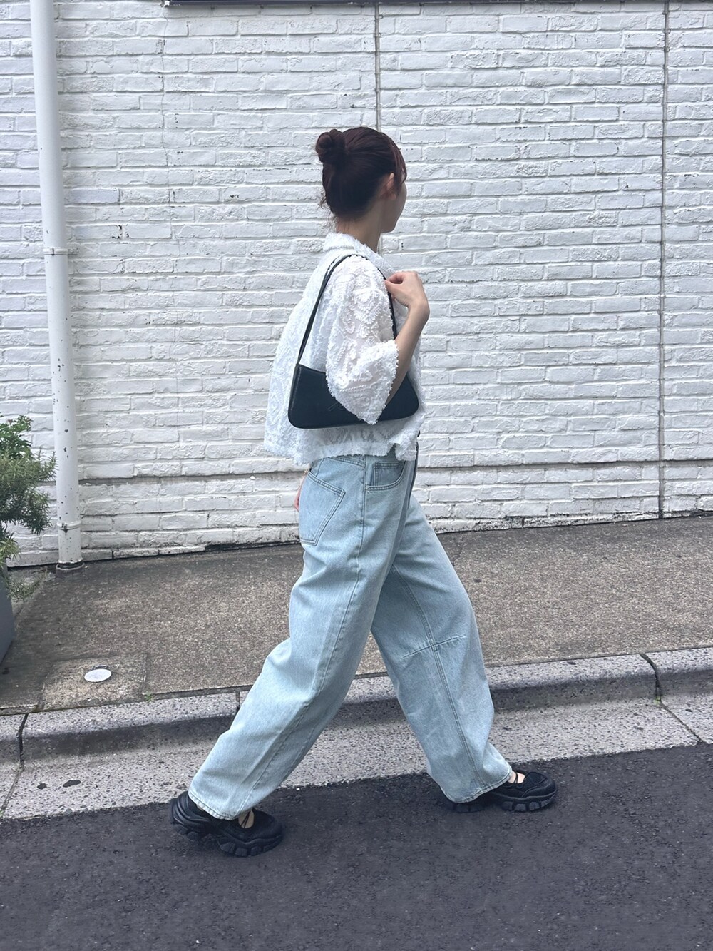 ブルー系のデニムパンツ、ブラック系のサンダル、ホワイト系のシャツ/ブラウスを着用したレディースの夏コーディネートの3枚目の写真