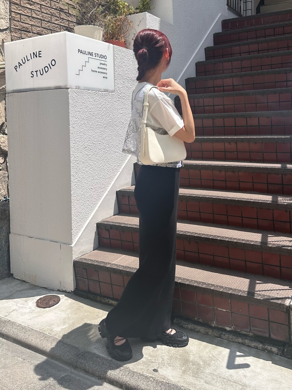 ブラック系のスカート、ブラック系のサンダル、シルバー系のベストを着用したレディースの夏コーディネートの2枚目の写真