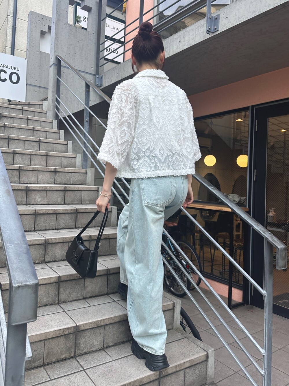 ブルー系のデニムパンツ、ブラック系のサンダル、ホワイト系のシャツ/ブラウスを着用したレディースの夏コーディネートの8枚目の写真