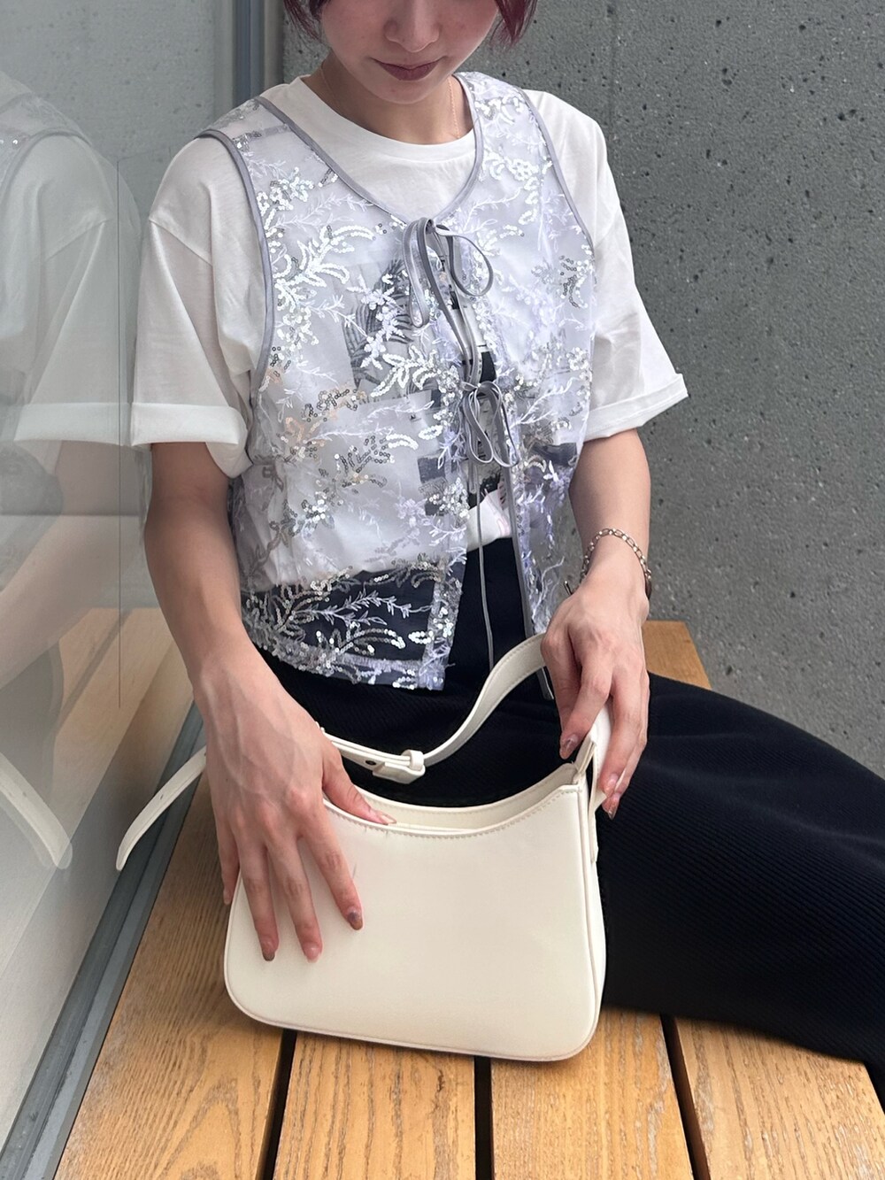 ブラック系のスカート、ブラック系のサンダル、シルバー系のベストを着用したレディースの夏コーディネートの5枚目の写真