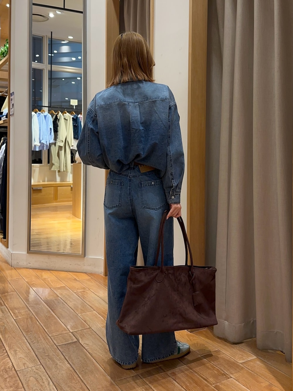 ブルー系のシャツ/ブラウス、ブルー系のデニムパンツ、ブラウン系のトートバッグを着用したレディースの春コーディネートの4枚目の写真