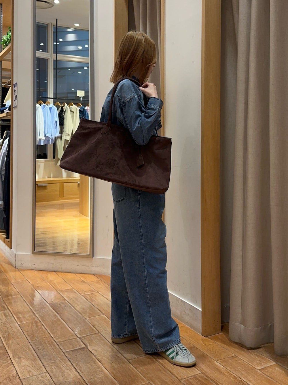 ブルー系のシャツ/ブラウス、ブルー系のデニムパンツ、ブラウン系のトートバッグを着用したレディースの春コーディネートの3枚目の写真