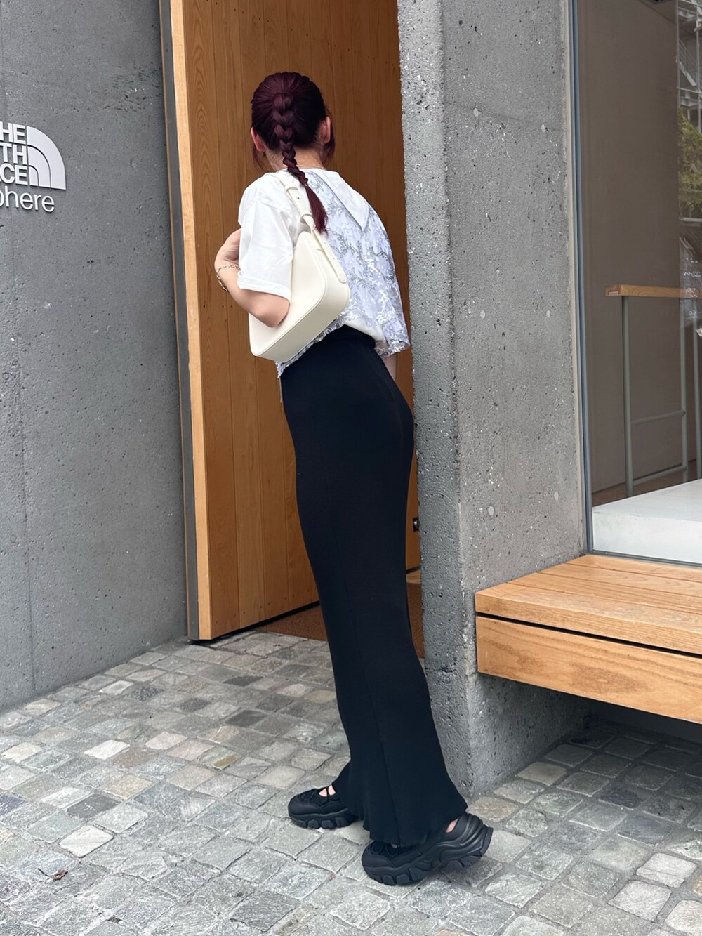 ブラック系のスカート、ブラック系のサンダル、シルバー系のベストを着用したレディースの夏コーディネートの6枚目の写真