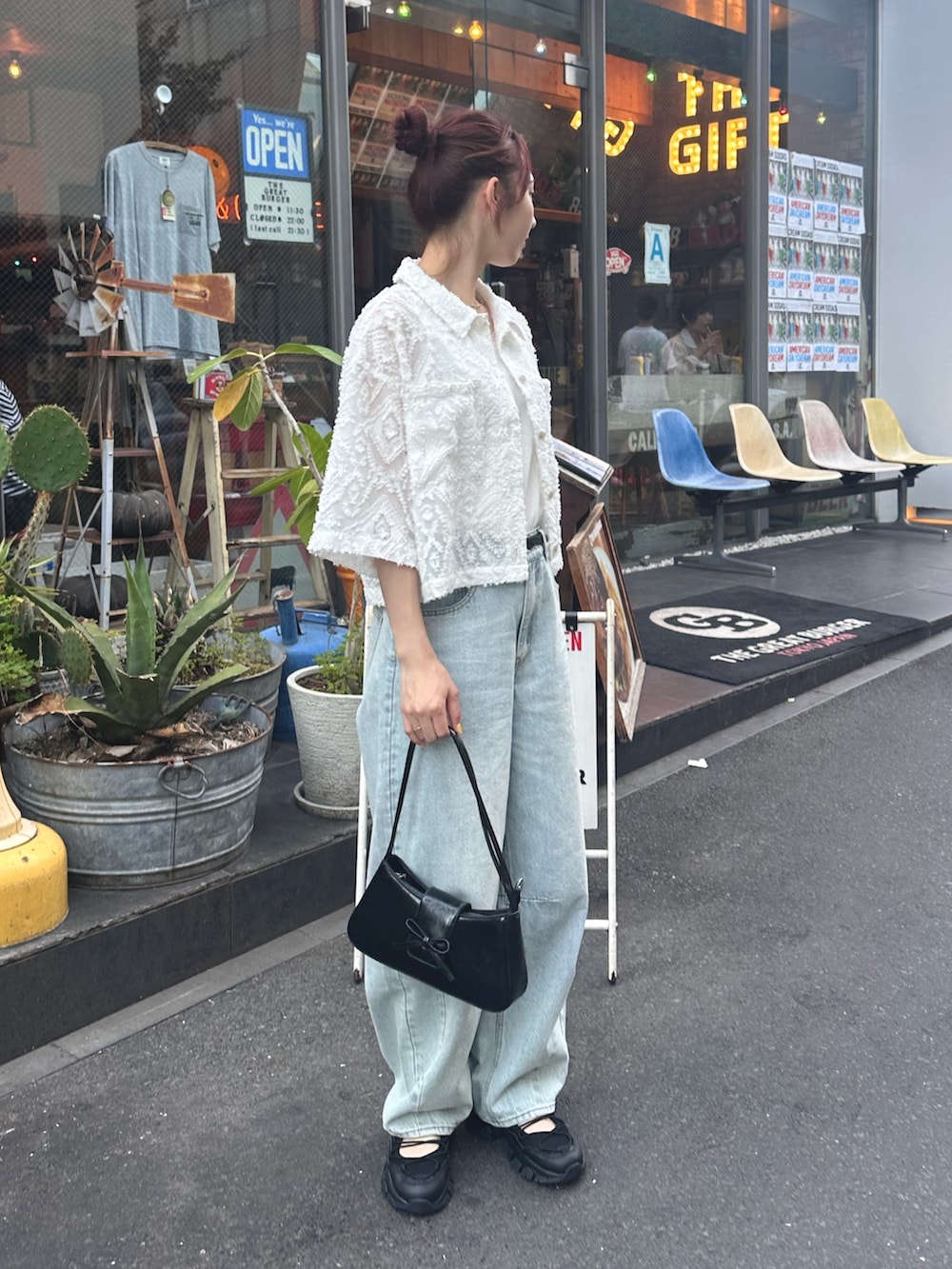 ブルー系のデニムパンツ、ブラック系のサンダル、ホワイト系のシャツ/ブラウスを着用したレディースの夏コーディネートの5枚目の写真
