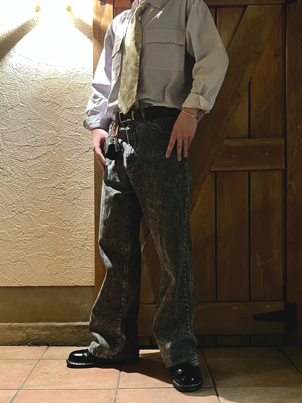 グレー系のデニムパンツ、グレー系のシャツ/ブラウス、ゴールド系のネクタイを着用したメンズの夏コーディネートの2枚目の写真