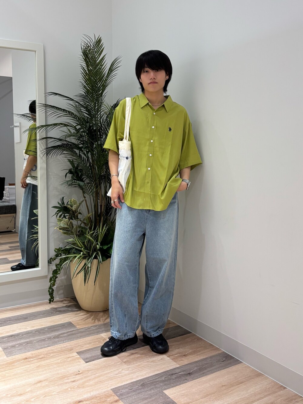 ブルー系のデニムパンツ、グリーン系のシャツ/ブラウス、ホワイト系のトートバッグを着用したメンズの春コーディネートの4枚目の写真