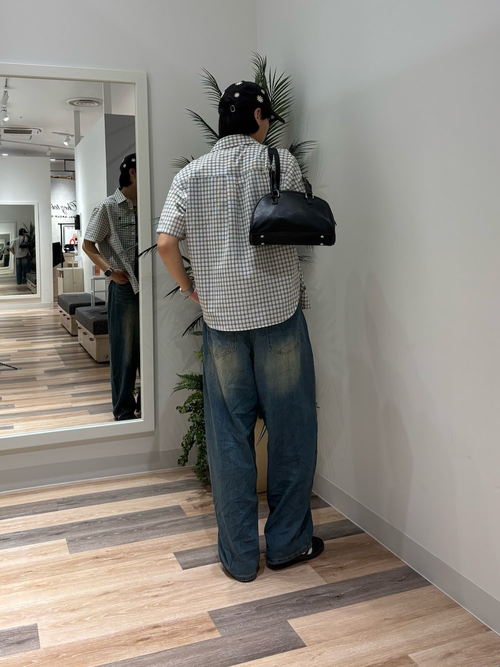 ブルー系のデニムパンツ、ホワイト系のシャツ/ブラウス、ブラック系のボストンバッグを着用したメンズの夏コーディネートの3枚目の写真