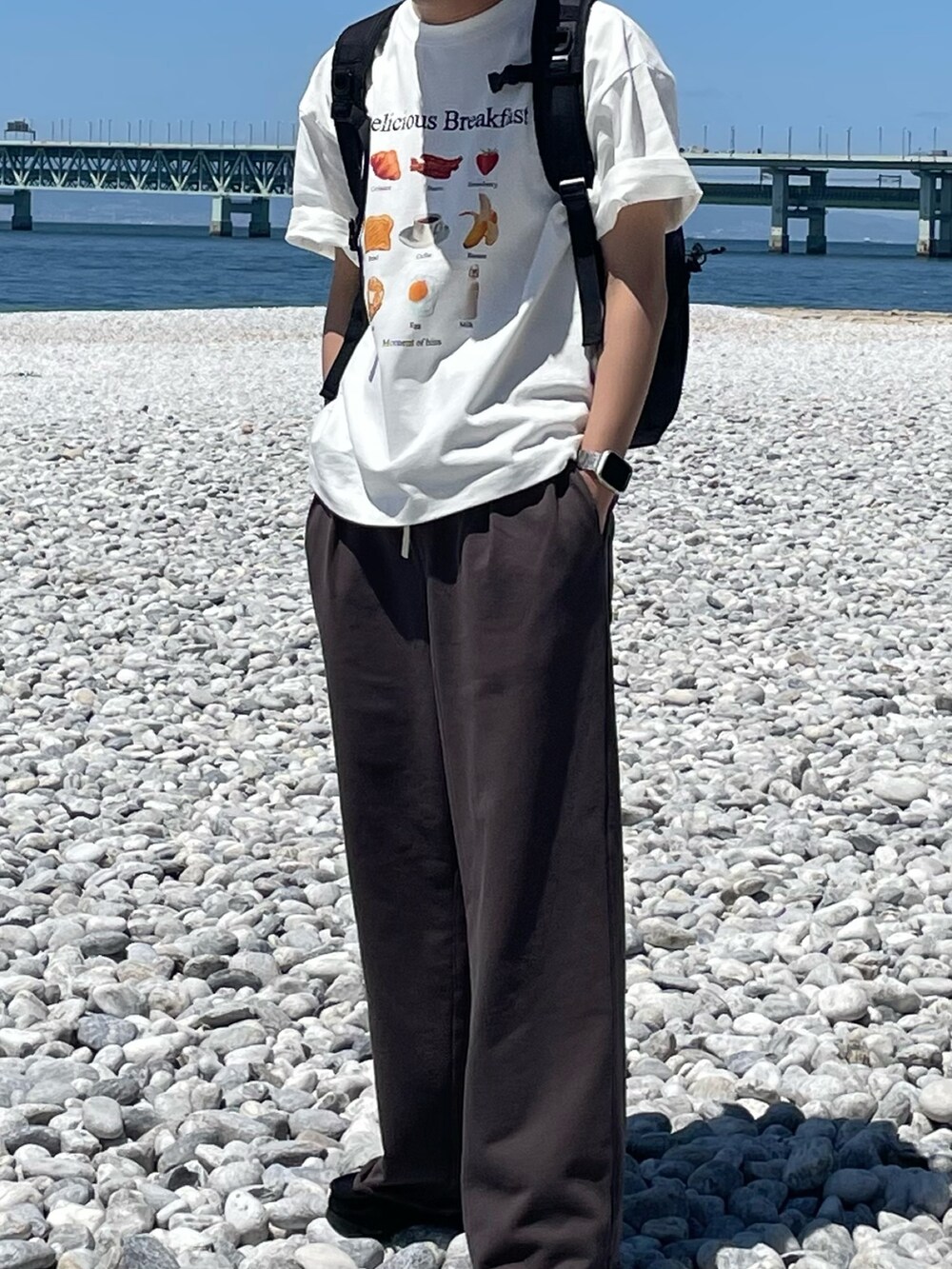 グレー系のその他パンツ、ホワイト系のTシャツ/カットソー、ブラック系のバックパック/リュックを着用したメンズの春コーディネートの3枚目の写真