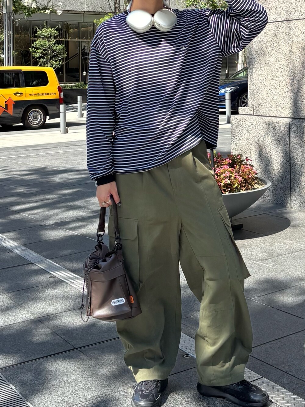 ブラウン系のショルダーバッグ、グリーン系のその他パンツ、ブラック系のTシャツ/カットソーを着用したメンズの夏コーディネートの2枚目の写真