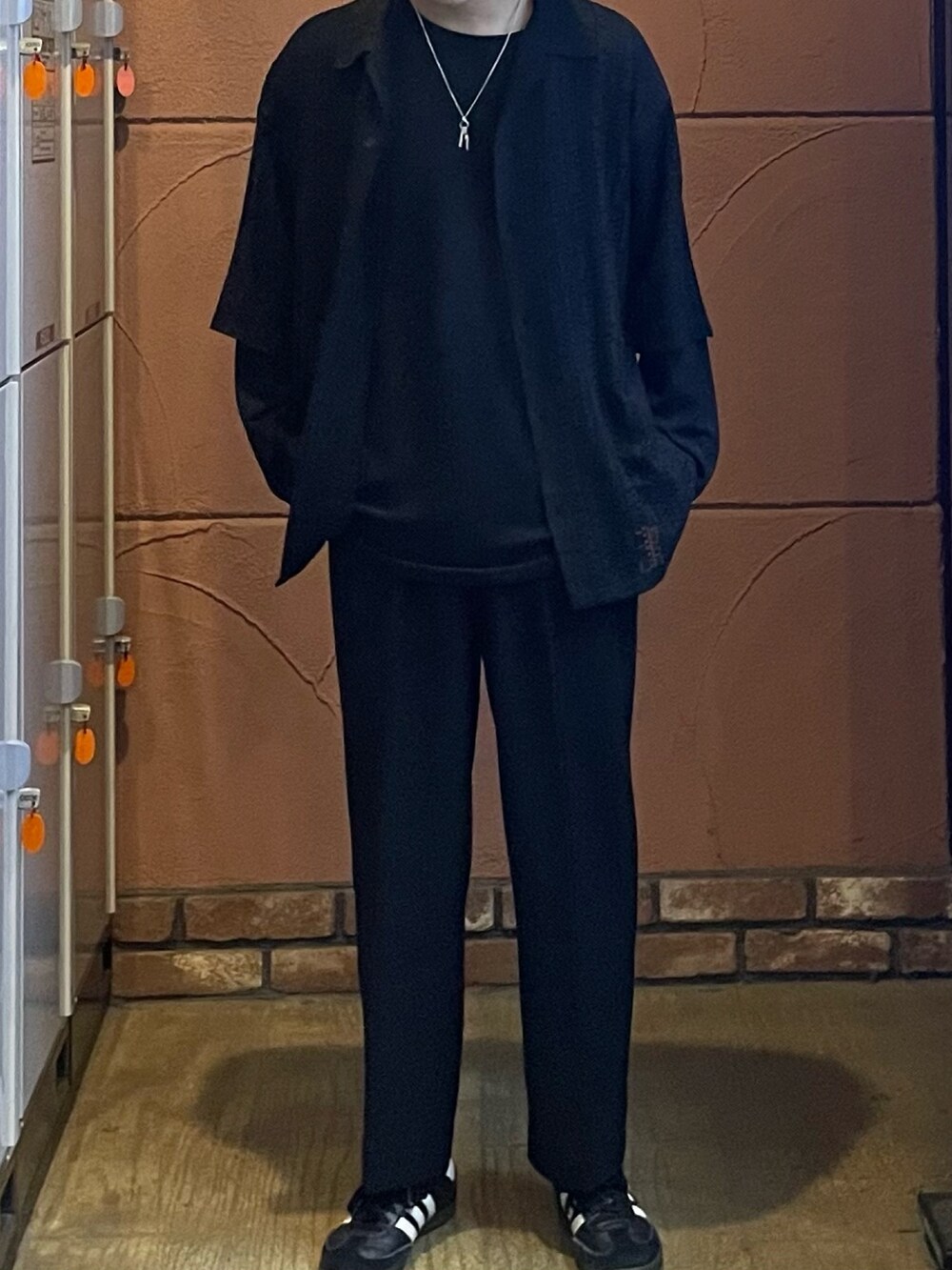 ブラック系のシャツ/ブラウス、ブラック系のスラックス、シルバー系のブレスレットを着用したメンズの春コーディネートの2枚目の写真