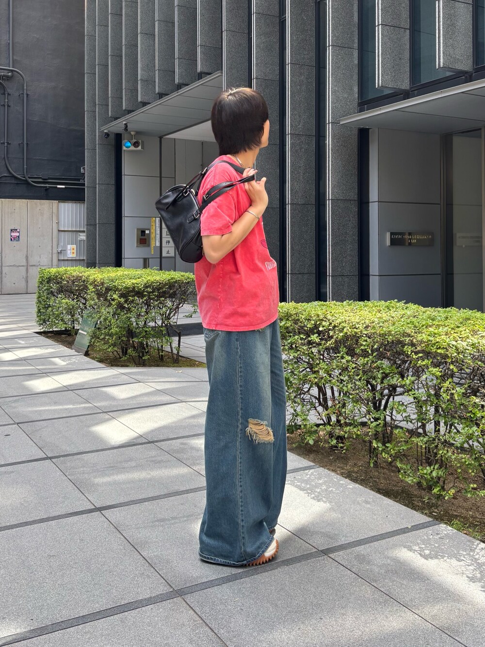 レッド系のTシャツ/カットソー、ブラック系のボストンバッグを着用したメンズの夏コーディネートの3枚目の写真