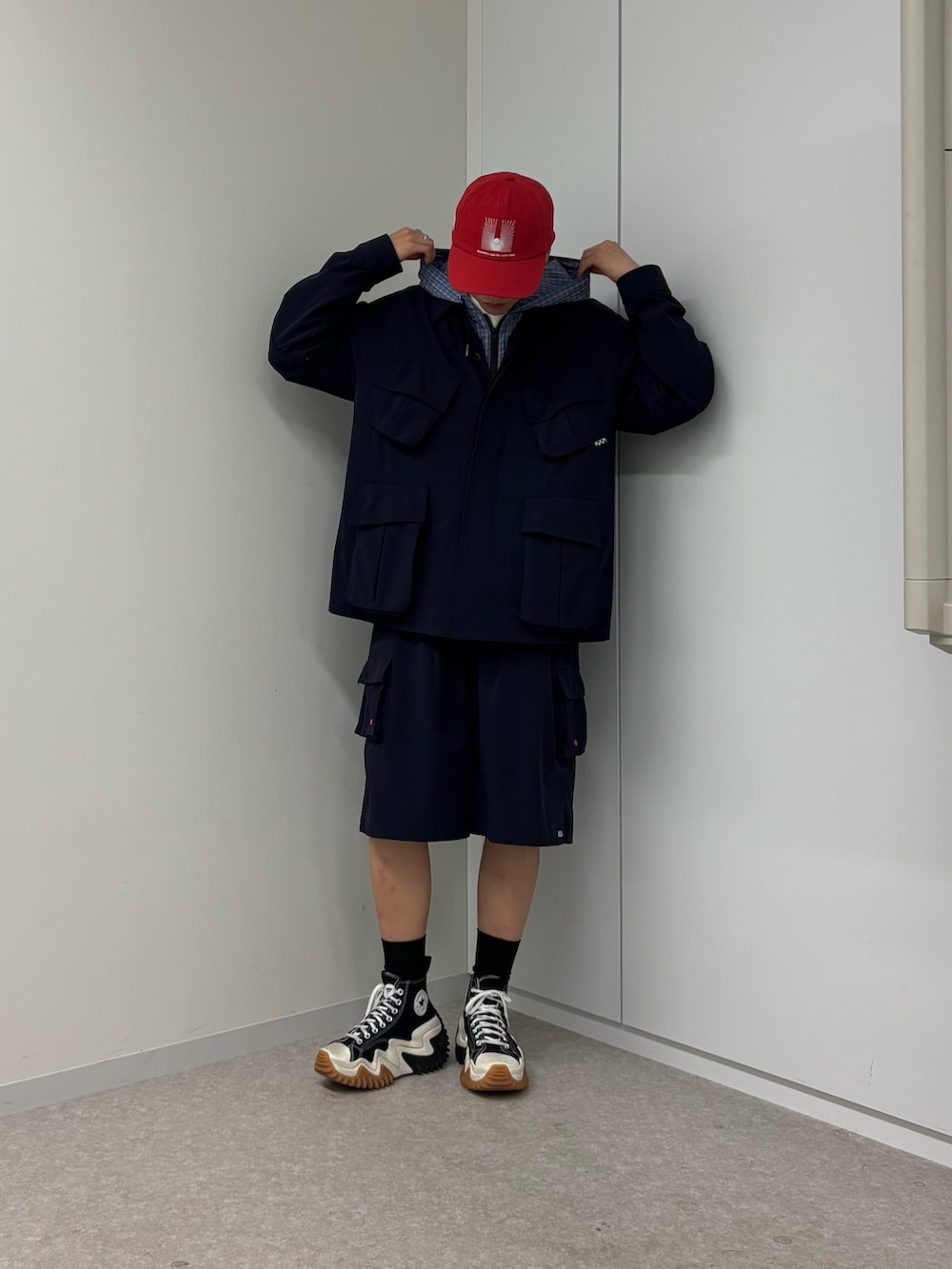 ブルー系のパーカー、レッド系のキャップを着用したメンズの春コーディネートの2枚目の写真