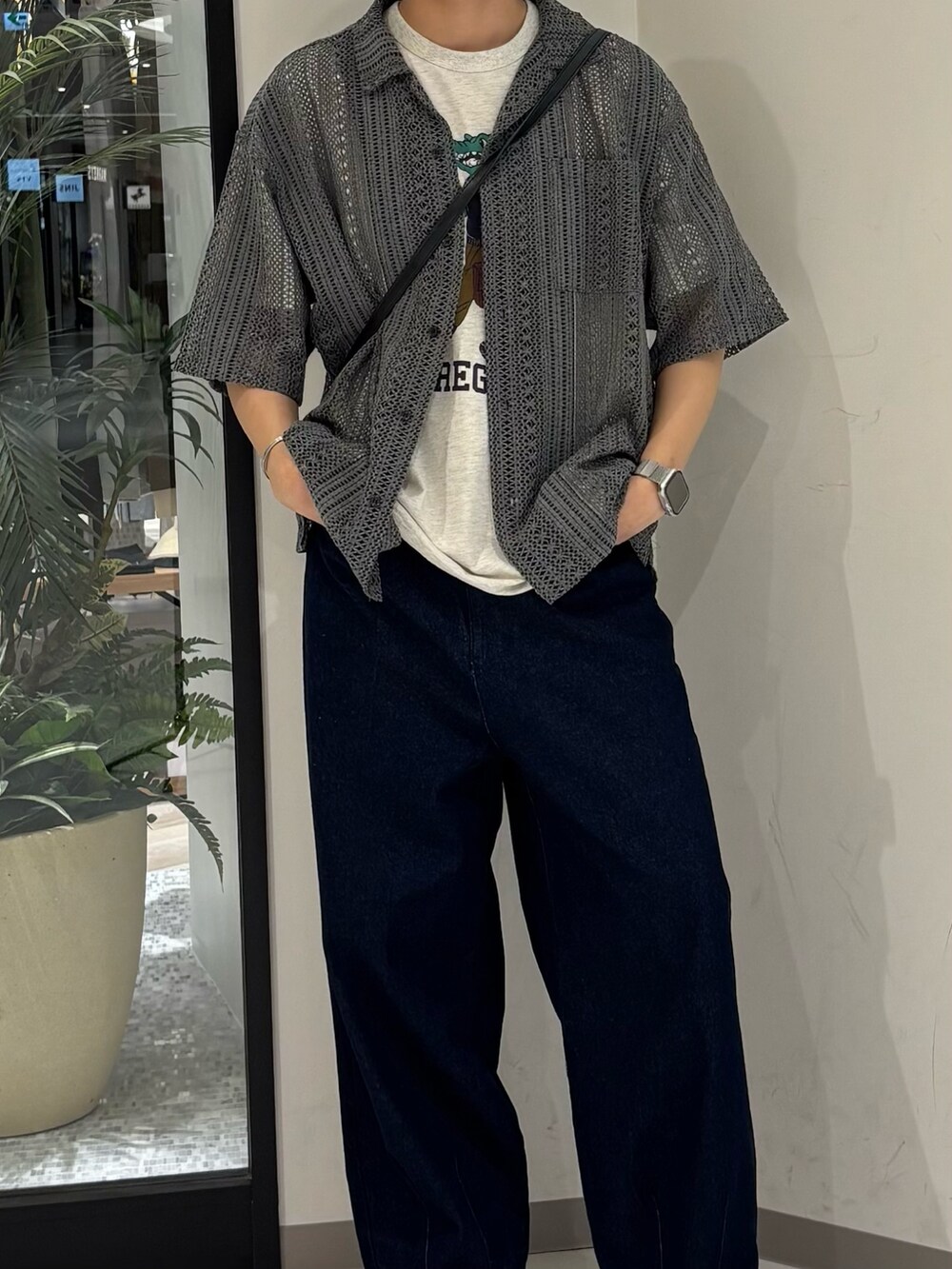 ブルー系のデニムパンツ、グレー系のTシャツ/カットソー、ブラック系のショルダーバッグを着用したメンズの夏コーディネートの2枚目の写真