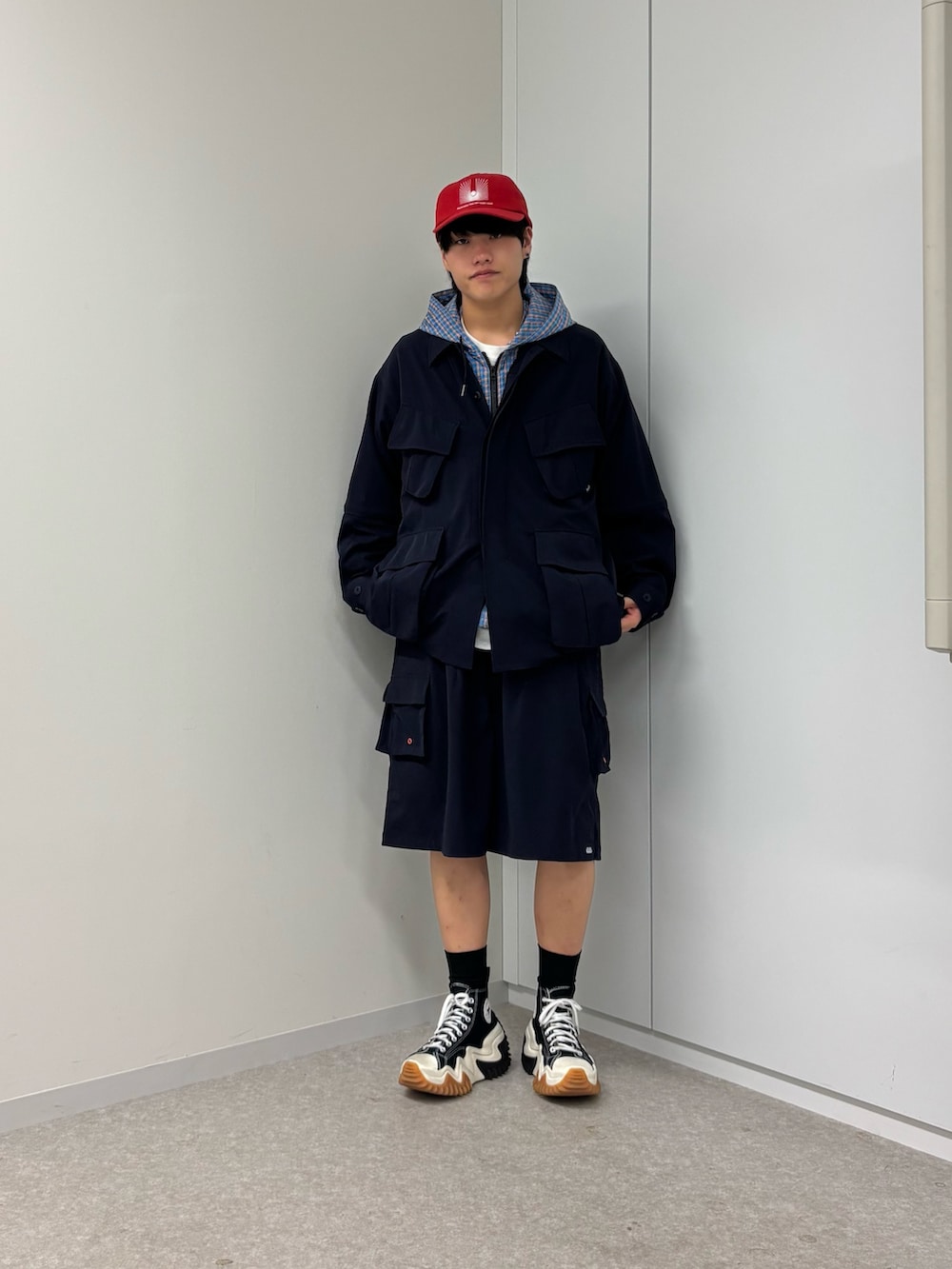 ブルー系のパーカー、レッド系のキャップを着用したメンズの春コーディネートの3枚目の写真