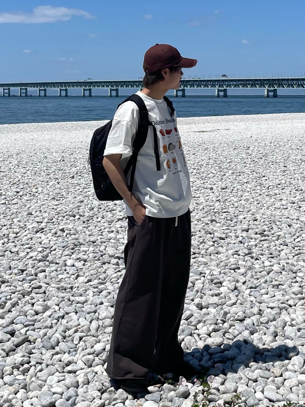 グレー系のその他パンツ、ホワイト系のTシャツ/カットソー、ブラック系のバックパック/リュックを着用したメンズの春コーディネートの2枚目の写真