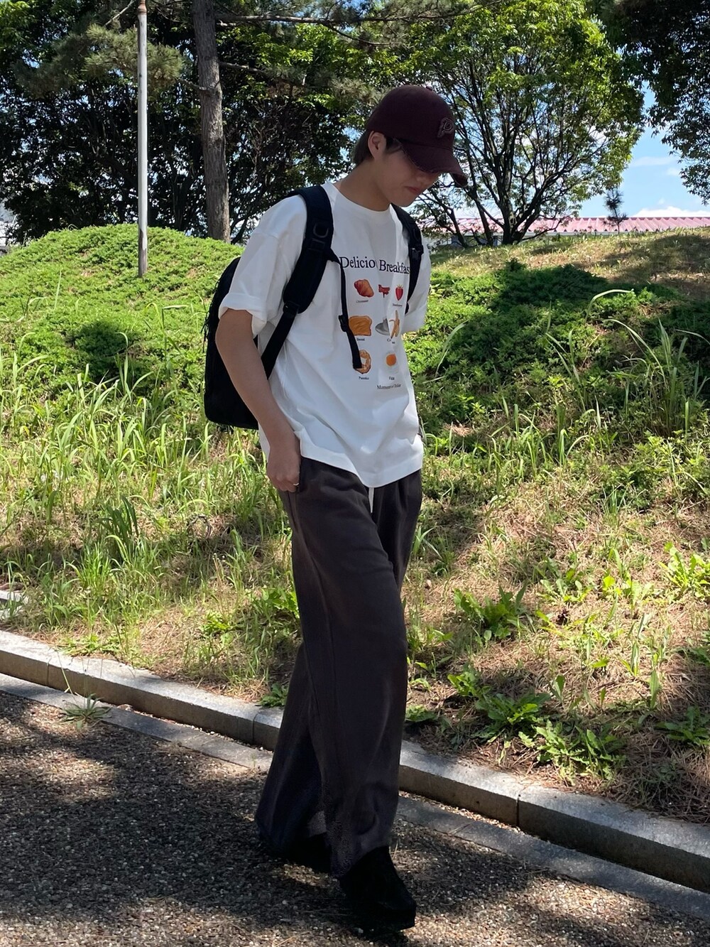 グレー系のその他パンツ、ホワイト系のTシャツ/カットソー、ブラック系のバックパック/リュックを着用したメンズの春コーディネートの4枚目の写真