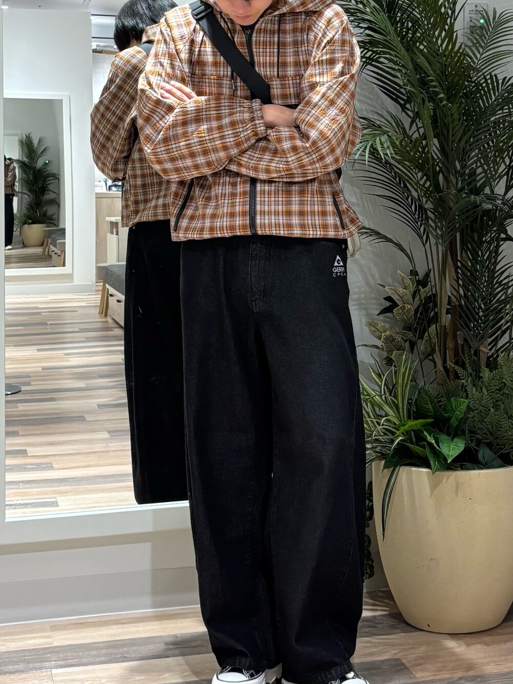 ブラック系のその他パンツ、オレンジ系のパーカーを着用したメンズの春コーディネートの2枚目の写真