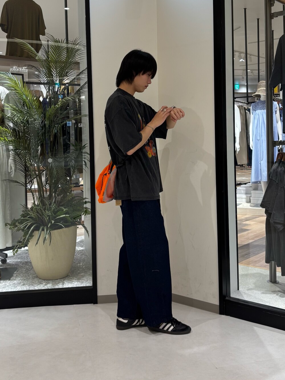 ブルー系のデニムパンツ、ブラック系のTシャツ/カットソー、オレンジ系のショルダーバッグを着用したメンズの夏コーディネートの3枚目の写真