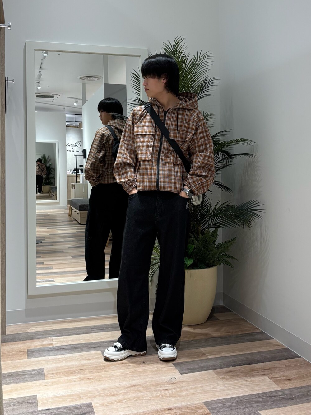 ブラック系のその他パンツ、オレンジ系のパーカーを着用したメンズの春コーディネートの3枚目の写真