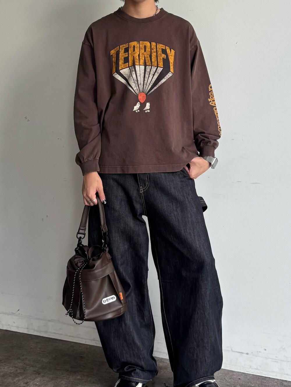 ブルー系のデニムパンツ、ブラウン系のショルダーバッグ、ブラウン系のTシャツ/カットソーを着用したメンズの夏コーディネートの2枚目の写真