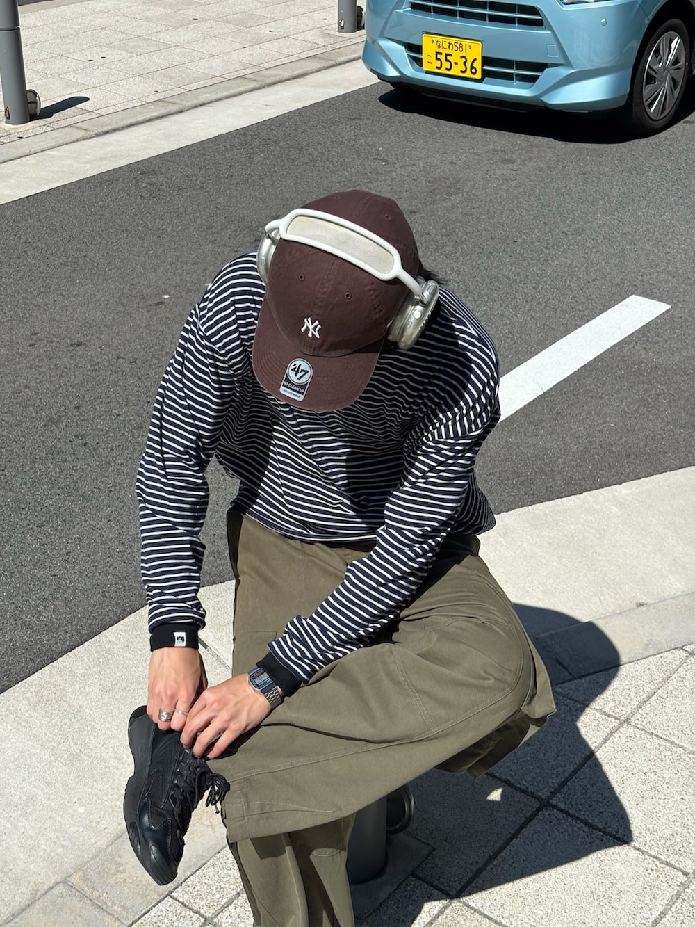 ブラウン系のショルダーバッグ、グリーン系のその他パンツ、ブラック系のTシャツ/カットソーを着用したメンズの夏コーディネートの3枚目の写真