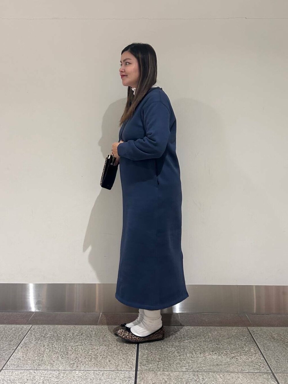 レッド系のショルダーバッグ、ホワイト系のTシャツ/カットソー、ブルー系のワンピースを着用したレディースの冬コーディネートの2枚目の写真