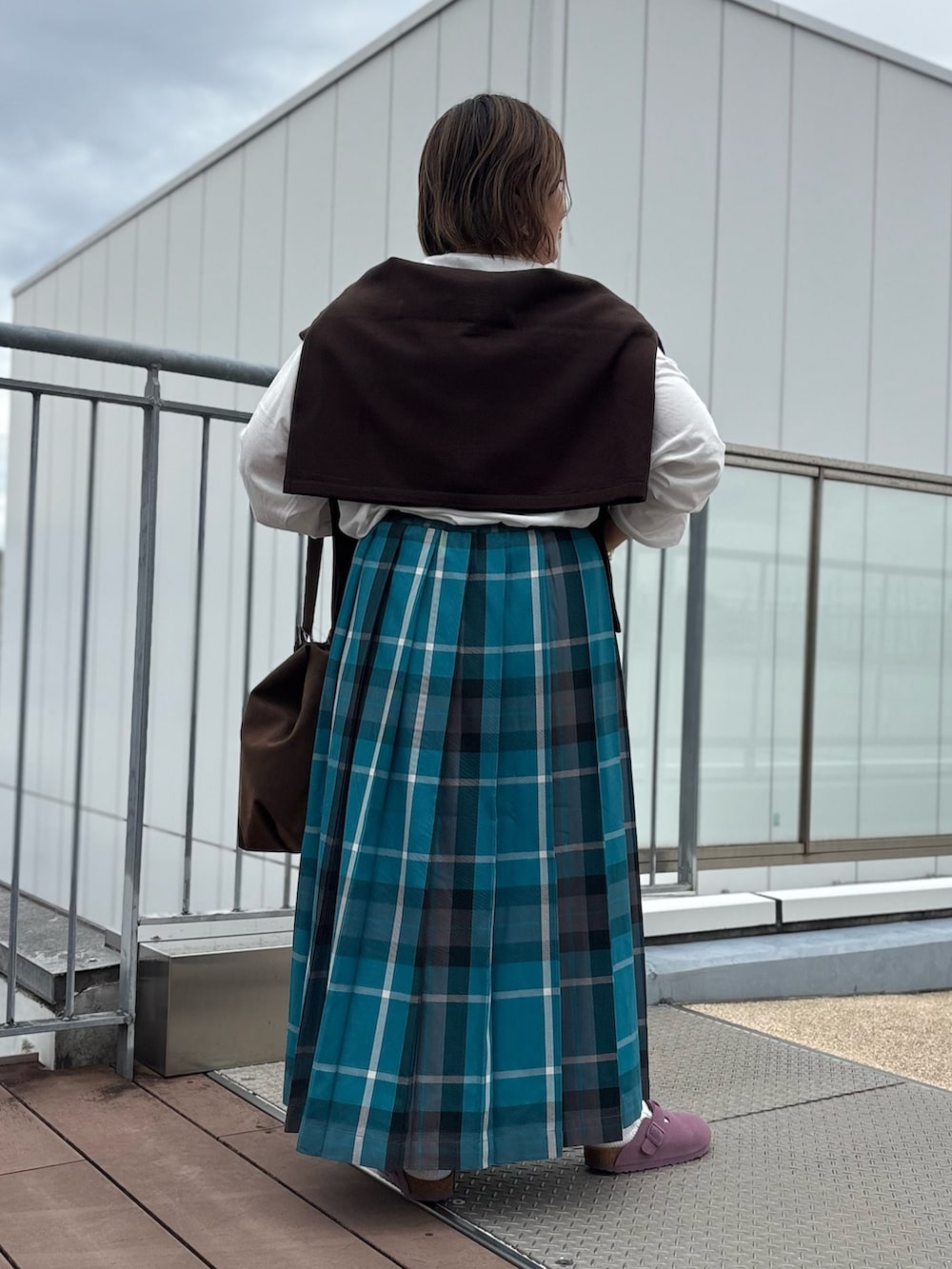 グリーン系のスカート、ブラウン系のカーディガン/ボレロ、ホワイト系のTシャツ/カットソーを着用したレディースの秋コーディネートの3枚目の写真