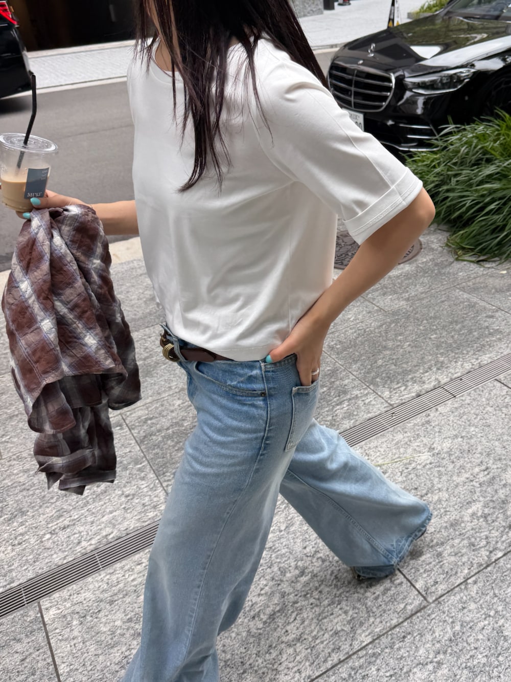 ブルー系のデニムパンツ、ブラウン系のベルトを着用したレディースの春コーディネートの4枚目の写真