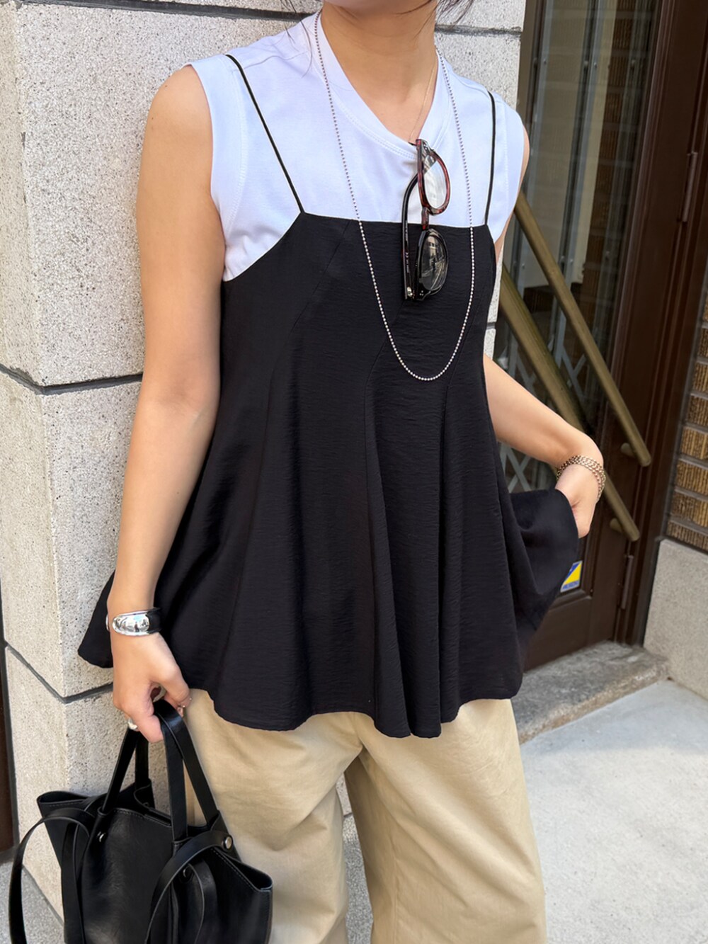 ブラック系のキャミソール、ホワイト系のTシャツ/カットソー、ベージュ系のその他パンツを着用したレディースの春コーディネートの2枚目の写真