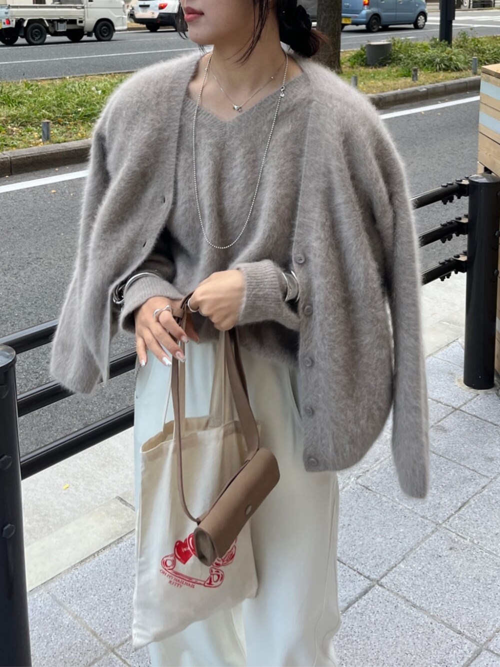 ベージュ系のショルダーバッグ、ブラウン系のニット/セーター、ブラウン系のカーディガン/ボレロを着用したレディースの冬コーディネートの5枚目の写真