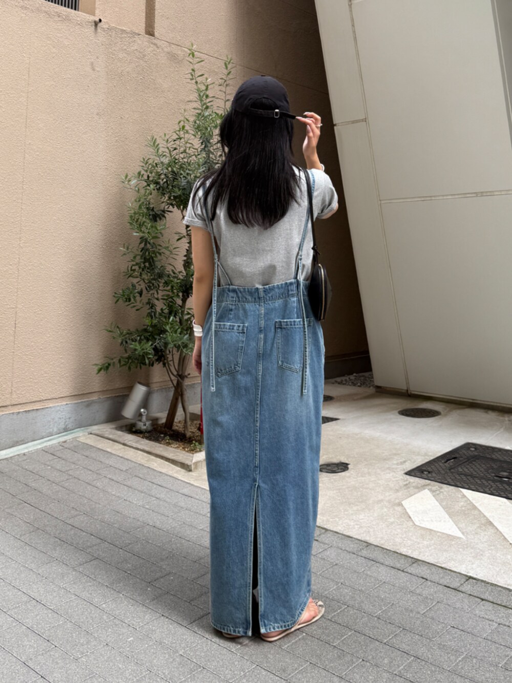 ブラック系のショルダーバッグ、ブルー系のワンピース、グレー系のTシャツ/カットソーを着用したレディースの春コーディネートの3枚目の写真