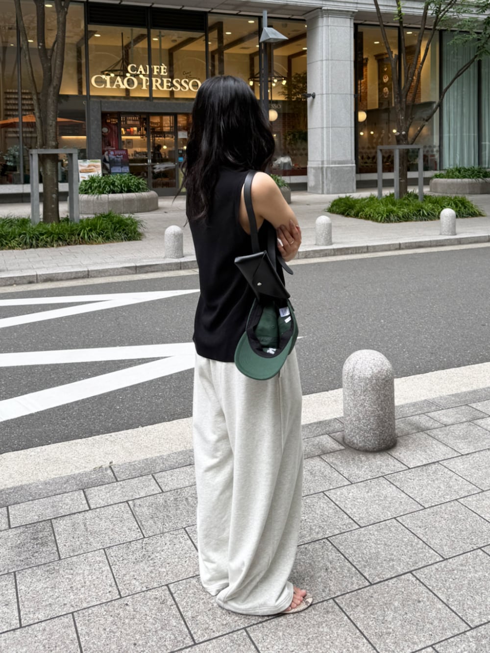 ブラック系のニット/セーター、ブラック系のショルダーバッグ、ベージュ系のその他パンツを着用したレディースの春コーディネートの3枚目の写真