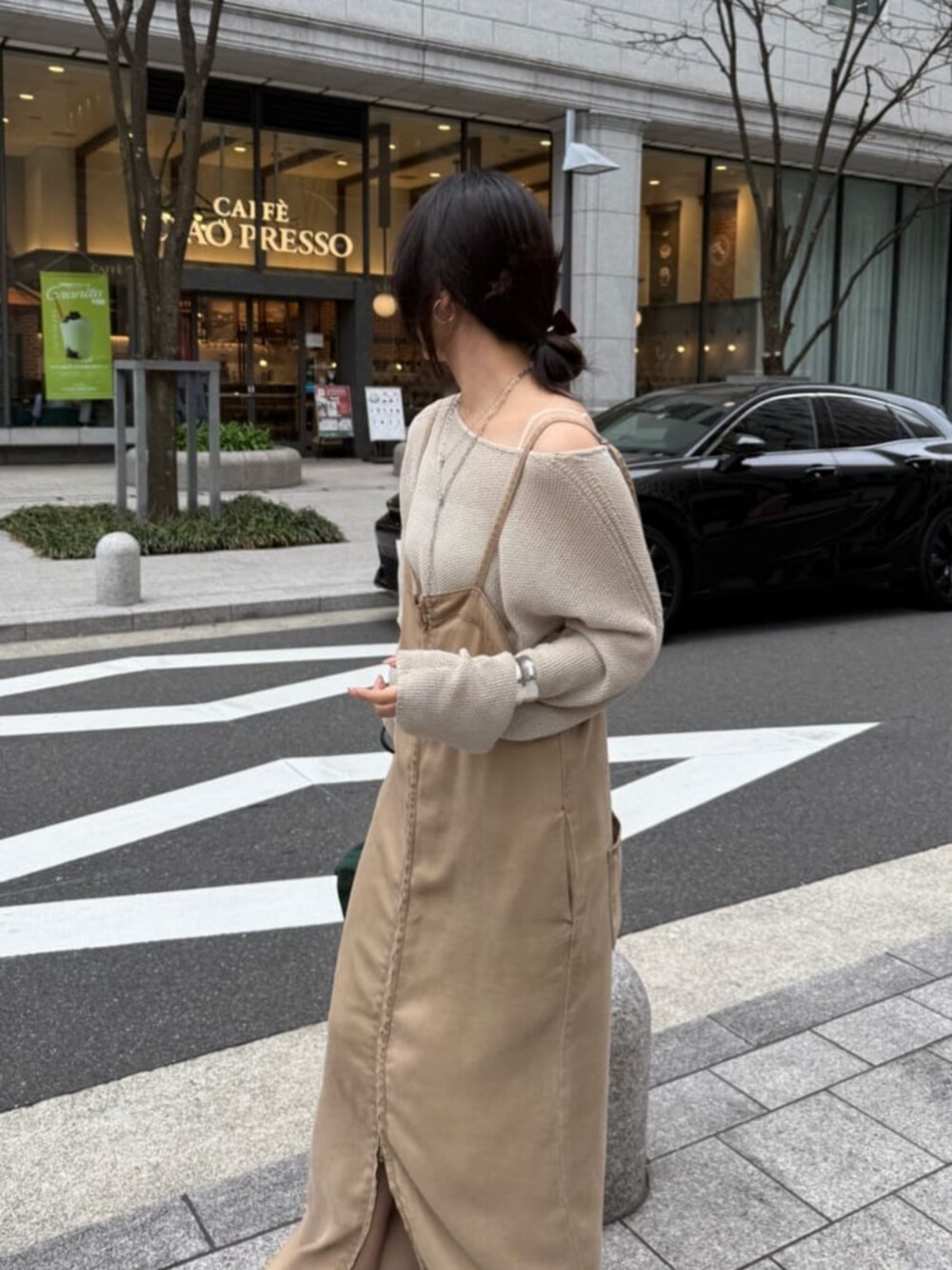 ブラック系のショルダーバッグ、ベージュ系のワンピース、ベージュ系のニット/セーターを着用したレディースの春コーディネートの2枚目の写真