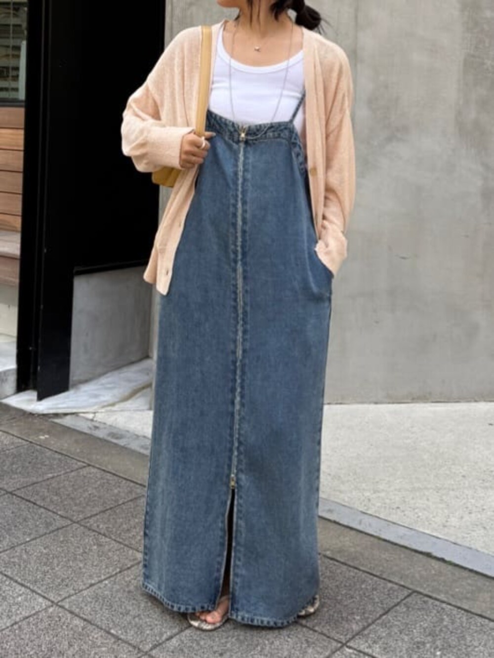 ブルー系のワンピース、ピンク系のカーディガン/ボレロを着用したレディースの春コーディネートの2枚目の写真