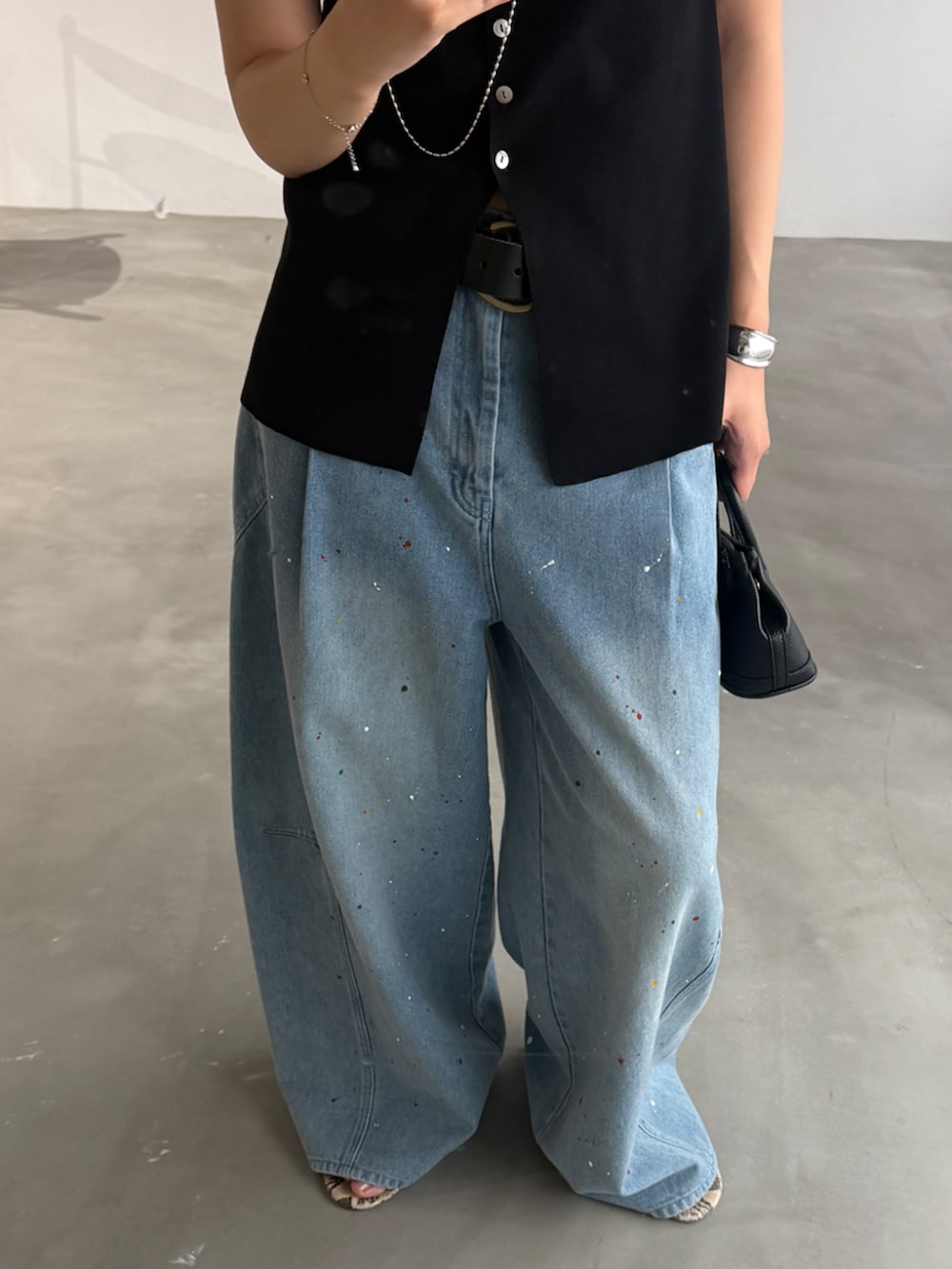 ブラック系のニット/セーター、ブルー系のその他パンツ、ブラック系のベルトを着用したレディースの夏コーディネートの2枚目の写真