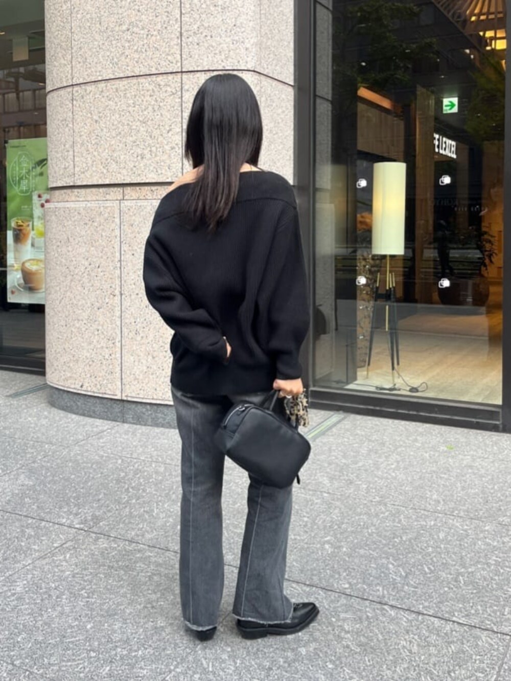 ブラック系のデニムパンツ、ブラック系のニット/セーター、ブラック系のショルダーバッグを着用したレディースの秋コーディネートの4枚目の写真