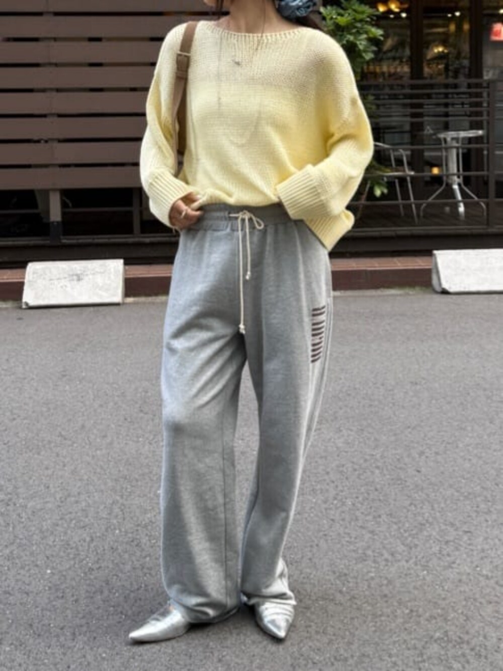 グレー系のその他パンツ、イエロー系のニット/セーターを着用したレディースの春コーディネートの2枚目の写真