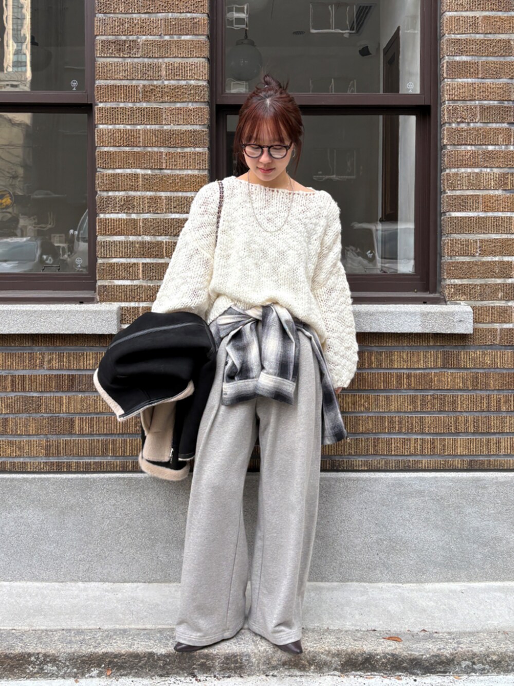 グレー系のその他パンツ、ブラック系のシャツ/ブラウス、ホワイト系のニット/セーターを着用したレディースの冬コーディネートの2枚目の写真