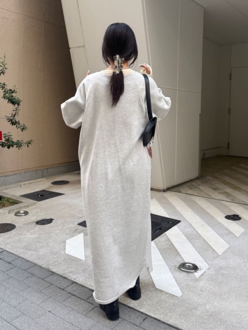 グレー系のワンピース、イエロー系のTシャツ/カットソーを着用したレディースの冬コーディネートの3枚目の写真