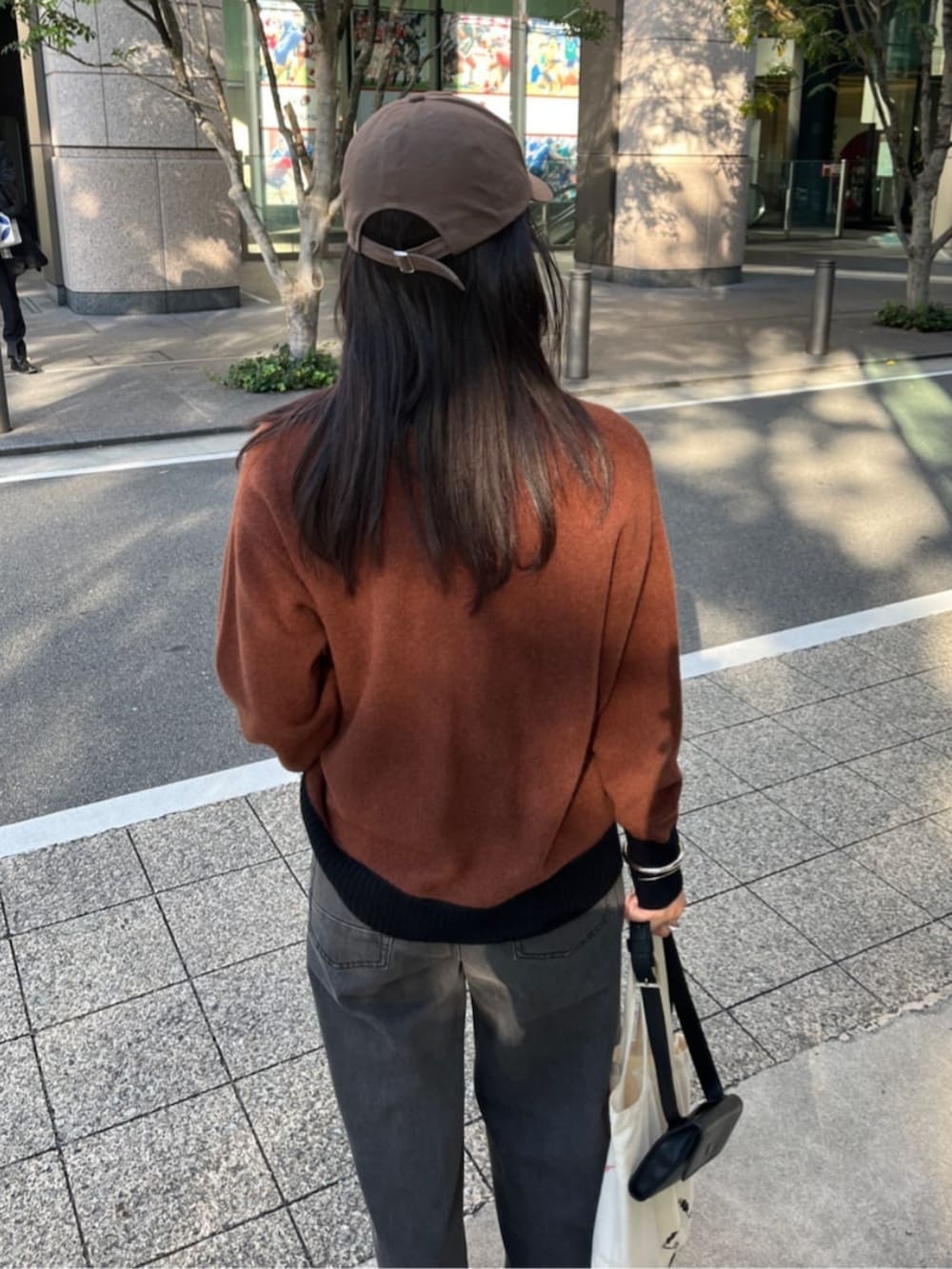ブラウン系のカーディガン/ボレロ、ブルー系のデニムパンツを着用したレディースの秋コーディネートの4枚目の写真