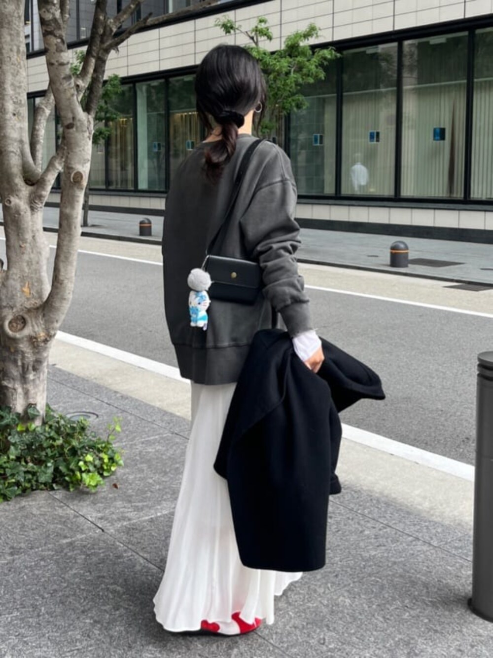 グレー系のTシャツ/カットソー、ホワイト系のスカート、ホワイト系のTシャツ/カットソーを着用したレディースの秋コーディネートの2枚目の写真