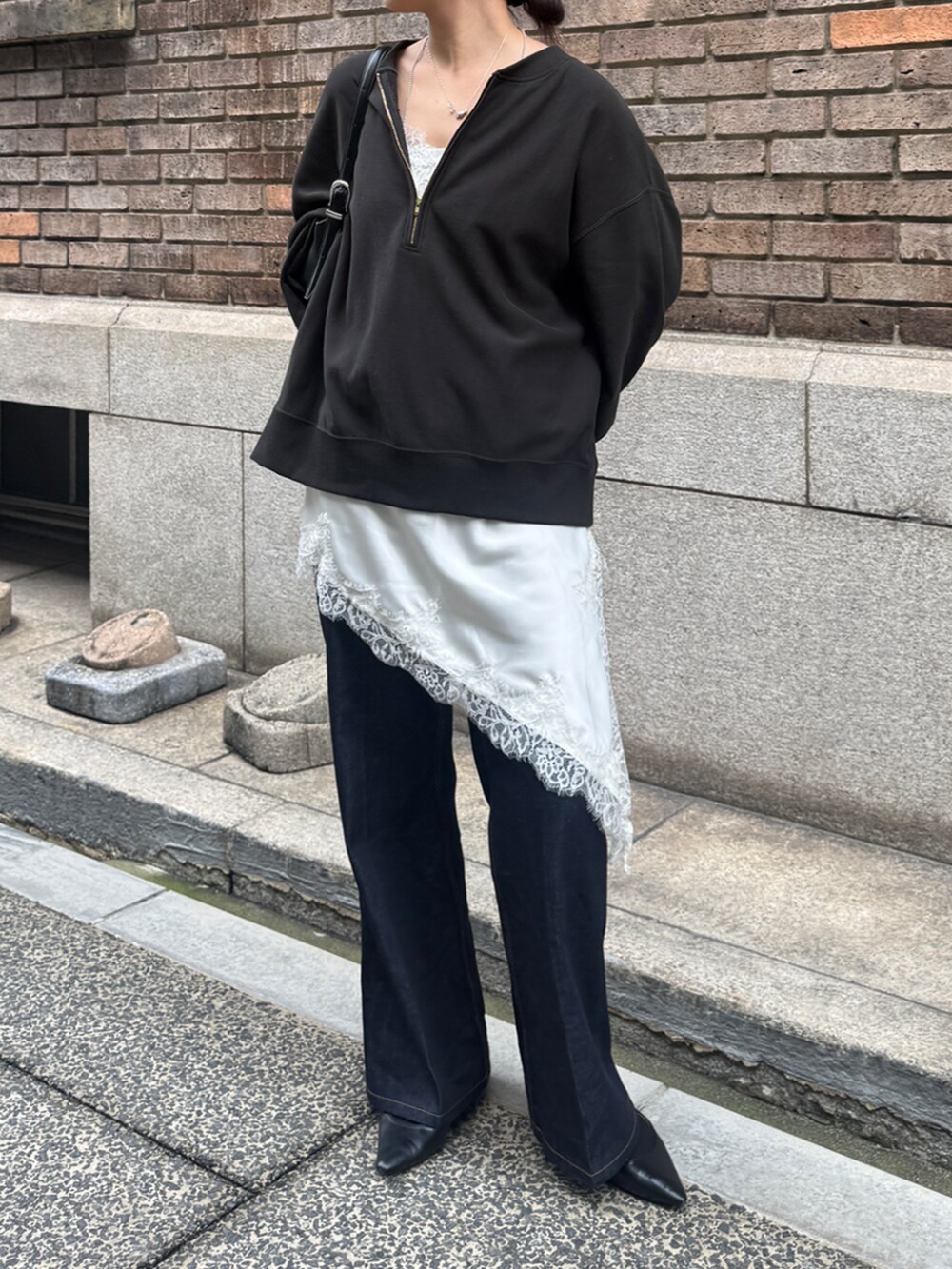 グレー系のスウェット、ホワイト系のキャミソール、ブルー系のデニムパンツを着用したレディースの秋コーディネートの2枚目の写真